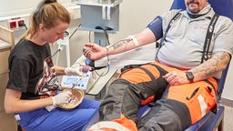 Medizinstudentin, nimmt bei Mario Genske von der Johanniter Motorradstaffel, Spender, während einer Blutspende im Rahmen der 6. Blutspende-Aktion «Bikers Blood for Help» am Universitätsklinikum Eppendorf (UKE) eine Probe für eine Laboruntersuchung ab.