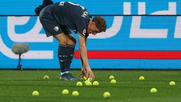 Bochum-Spieler Patrick Osterhage sammelt Tennisbälle auf