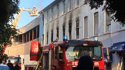 Die Feuerwehr löscht ein Mehrfamilienhaus in Iserlohn von außen