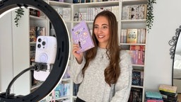 Die Buch-Influencerin Julia Holz filmt sich mit einem Buch