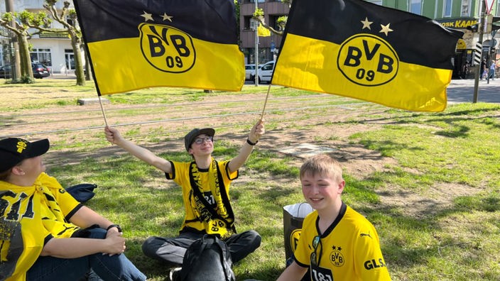 BVB-Fans am Borsigplatz in Trikots und mit Fahnen
