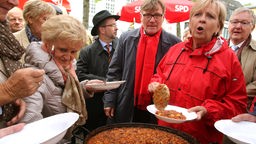 Die nordrhein-westfälische Ministerpräsidentin Hannelore Kraft (r) und der Bundestagsabgeordnete Sigmund Ehrmann (beide SPD) verteilen am 20.09.2013 am Wahlstand der SPD in Moers Chili an die Bürger