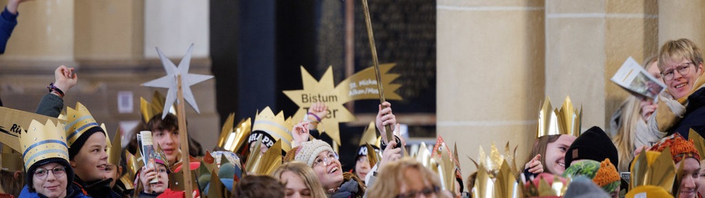 Sternsinger erheben ihre Sternenschilder