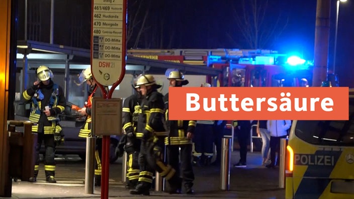 Feuerwehrmänner stehen an einer Bushaltestelle -Buttersäure