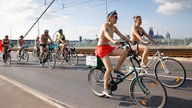 eilnehmer des «Cologne Naked Bike Ride» fahren leicht bekleidet auf ihren Fahrrädern durch die Innenstadt und über die Severinsbrücke in Köln