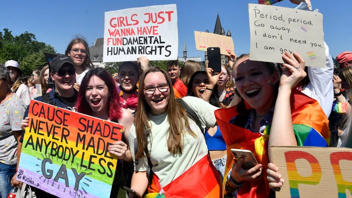 Teilnehmerinnen halten Schilder mit Aufschriften wie "Girls just wanna have fundamental human rights" und "cause shade never made anybody less gay".