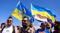 Teilnehmende der Parade des CSD in Köln ziehen mit ukrainischen Nationalflaggen durch die Stadt und bekunden ihre Solidarität