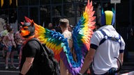 Ein Mann mit Regenbogenflügeln beim CSD in Köln