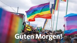 Teilnehmer am Kölner Christopher Street Day 2019 unter dem Motto '50 Years of Pride' auf der Deutzer Brücke, davor ein Banner mit der Aufschrift "Guten Morgen!"