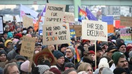 Demonstrierende in Köln halten selbstgemalte Plakate hoch