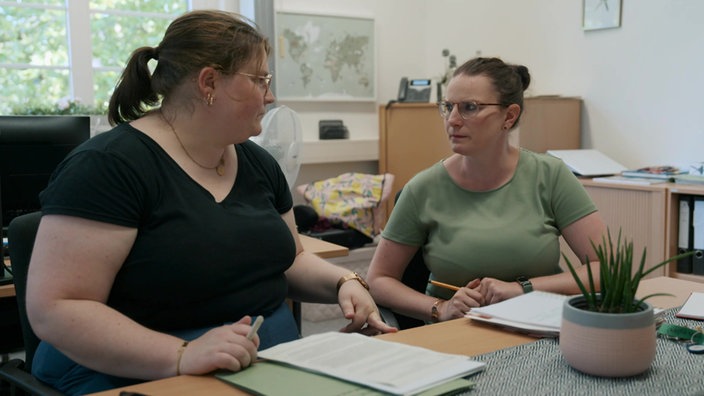 Sophie Schöttler sitzt mit ihrer Vorgesetzten in einem Büro im Jugendamt. Die beiden Frauen sprechen miteinander und schauen einander an.