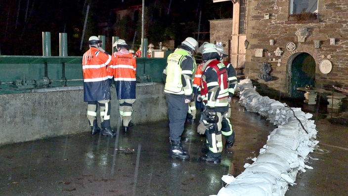 Solingen: Einsatzkräfte der Feuerwehr sind bei einer durch Dauerregen überfluteten Straße im Einsatz