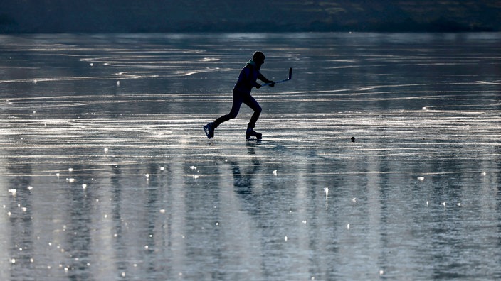 Ein Junge spielt Eishockey auf dem zugefrorenen Decksteiner Weiher