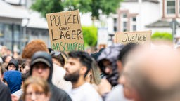 Demonstranten mit polizeikritischen Plakaten bei der Kundgebung in Herford.