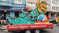 An der Spitze fährt ein Wagen des Düsseldorfer Künstlers Klaus Klinger, der ein einäugiges Monster mit einer Inflationsbombe zeigt 