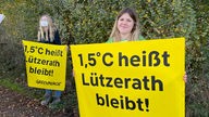 Klimaktivistinnen protestieren und halten Plakate von Greenpeace