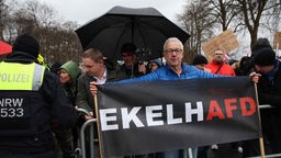 Thomas Hein mit einem Banner mit der Aufschrift „EkelhAFD“