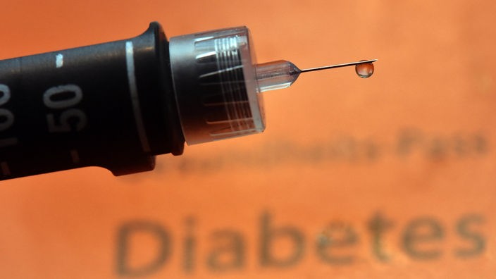 Ein Tropfen Insulin hängt an der Nadel einer wiederverwendbaren Spritze, einem sogenannten Pen, für Diabetiker