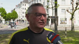 Bernd Naumann aus Grüstrow wird in seinem BVB Trikot interviewt