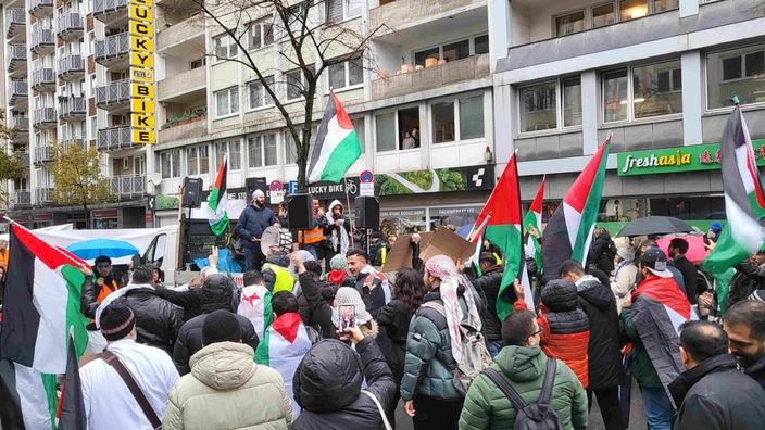 Demonstrierende gegen Antisemitismus hören auf der Straße einer Rede zu