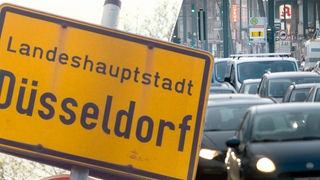 Ortsschild Düsseldorf und Berufsverkehr auf der Corneliusstrasse in Düsseldorf