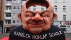 Eine Figur von Kanzler Scholz mit einem hohlen Kopf beim Rosenmontagszug in Düsseldorf