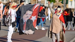 Zwei Frauen halten eine Fahne mit dem Abbild des türkischen Präsidenten Erdogan 