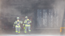 Einsatzkräfte der Feuerwehr am verrauchten Unfallort in Gevelsberg.