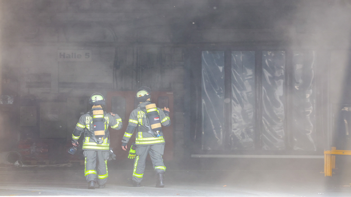 Einsatzkräfte der Feuerwehr am verrauchten Unfallort in Gevelsberg.