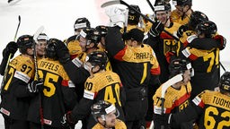 Deutsche Spieler der Eishockey-Nationalmannschaft freuen sich auf dem Spielfeld