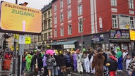 Menschen in Kostümen benutzen ein Urinal auf der Zülpicher Straße