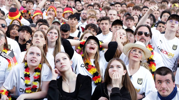 Jubelnde Fans in der Fanzone am Friedensplatz in Dortmund blicken am 19.06.2024 auf die Leinwand.