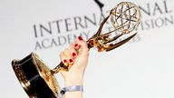Eine hochgehaltene Trophäe der International Emmy Awards