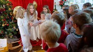 Eine Darstellerin des Christkindes (M) nimmt in der Christkindpostfiliale der Deutschen Post Wunschzetteln von Kindern entgegen