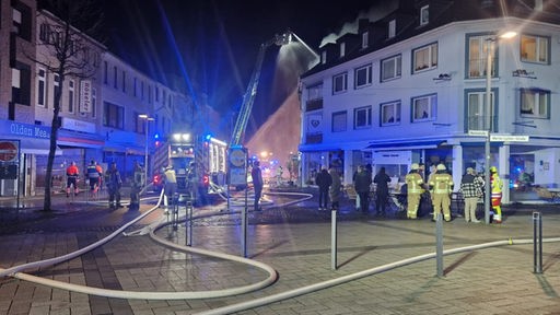 Fußgängerzone mit Feuerwehreinsatz nach Explosion in einem Wohn- und Geschäftshaus