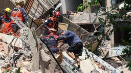 Rettungskräfte helfen einem Überlebenden, nachdem er aus einem beschädigten Gebäude in New Taipei City gerettet wurde