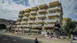 Türkei, Iskenderun: Ein Polizist bewacht ein eingestürztes Gebäude in Iskenderun, das bei dem schweren Erdbeben im Süden der Türkei am 6. Februar zerstört wurde