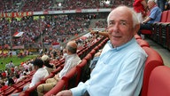 Ernst Huberty sitzt im Stadion des 1. FC Köln.