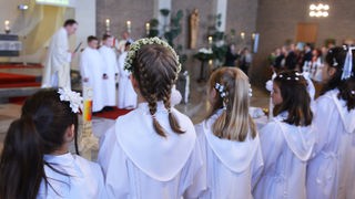 Kommunionkinder in der Kirche bei der Erstkommunion (Rückenansicht)