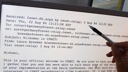  Eine Hand zeigt auf einem Monitor auf die erste empfangene E-Mail in Deutschland, 1984