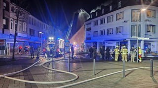 Fußgängerzone mit Feuerwehreinsatz nach Explosion in einem Wohn- und Geschäftshaus