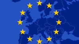 Man sieht die gelben Europasterne, im Hintergrund eine blaugefärbte Landkarte Europas