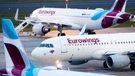 Mehrere Eurowings-Maschinen stehen auf einem Flughafen.