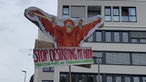 Demonstration in Münster. Jemand hält ein großes, selbstgebasteltes Plakat hoch, auf dem ein Orang Utan zu sehen ist mit der Unterschrift: "Stop destroying my planet."