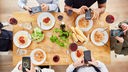 Freunde machen Foodie Foto mit Smartphone von Mahlzeit von oben