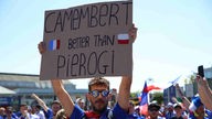 Fan hält Plakat hoch mit der Aufschrift: "Camembert better than Pierogi"