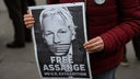 Eine Demonstrantin hält ein Plakat mit den Worten "Free Assange" in den Händen.
