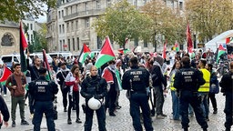 Polizisten und Demonstranten stehen auf einem Platz.