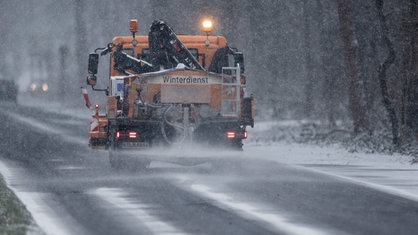  Ein Räum- und Streufahrzeug des Winterdienstes fährt im dichten Schneetreiben in Köln