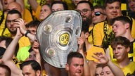Jubelnde Borussia Dortmund Fans mit Attrappe der Meisterschale
